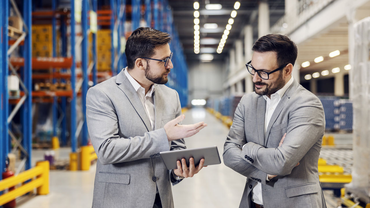Two business owners talking to each other inside the warehouse