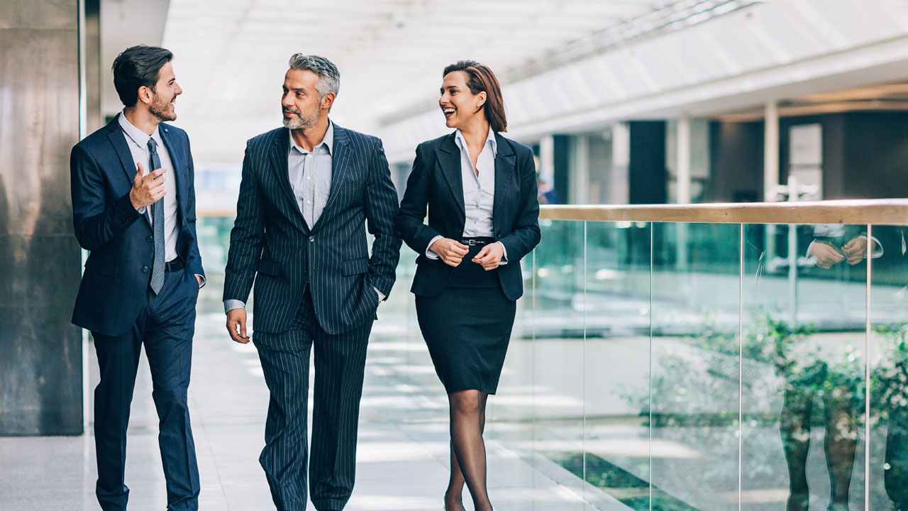 Three people in suit having a walking while talking